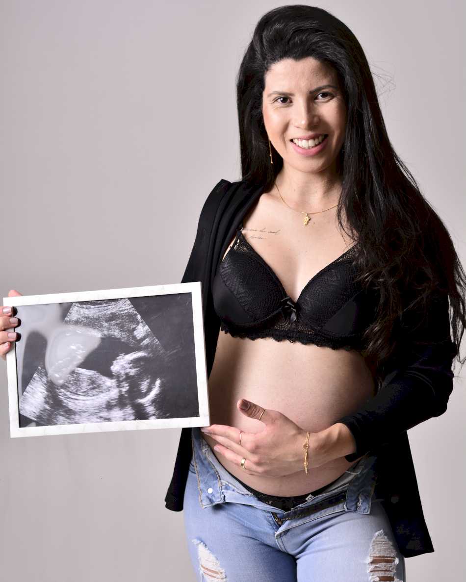 Gestante posando com foto nas mãos em um ensaio de gestante em Raposos Gestante posando com foto nas mãos em um ensaio de gestante em Raposos