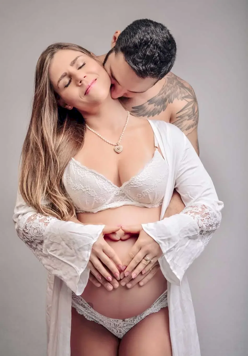 Noiva com seu marido pousando para um ensaio de gestante Noiva com seu marido pousando para um ensaio de gestante